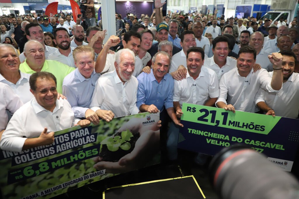 O governador Carlos Massa Ratinho Junior desembarcou em Cascavel nesta segunda-feira (09) para a abertura do Show Rural Coopavel com a caneta cheia. Aproveitando a vitrine de um dos maiores eventos do agronegócio da América Latina, o chefe do Executivo estadual anunciou um pacote de investimentos que soma quase R$ 38 milhões.Os recursos abrangem três frentes estratégicas: infraestrutura logística, educação básica e ensino técnico agrícola. O maior destaque ficou para a solução de um gargalo histórico na BR-277 e a modernização da frota de colégios que formam a mão de obra do campo.Fim do gargalo no Cascavel Velho
A obra mais aguardada pela população local foi confirmada: a construção da trincheira na BR-277, que ligará os bairros Região do Lago e Cascavel Velho. O Governo do Estado vai investir R$ 21,1 milhões para acabar com um dos pontos mais críticos de mobilidade e acidentes na rodovia.A nova estrutura prevê uma passagem inferior e a duplicação do trecho, conectando a Rua Munique à Rua Waldemar Casagrande. A obra deve beneficiar diretamente mais de 65 mil moradores que hoje sofrem com congestionamentos no Trevo do Portal.“Estamos comemorando este dia de Show Rural com grandes anúncios, como a ligação entre a Cascavel Velha e a cidade moderna, superando a divisão causada pela rodovia”, afirmou Ratinho Junior.Tecnologia para a futura geração do Agro
Reforçando a vocação do estado, o governador entregou R$ 6,85 milhões em equipamentos para 26 colégios agrícolas da rede estadual. A lista inclui desde tratores e carretas basculantes até drones e composteiras elétricas.O objetivo é transformar as escolas em "cooperativas-escola", onde o aluno aprende operando a mesma tecnologia de ponta que encontrará nas grandes fazendas e indústrias.“Nós transformamos os colégios agrícolas em verdadeiras cooperativas-escola. A ideia é que esses jovens saiam preparados tecnicamente, mas também com a cabeça cooperativista, que é o DNA do Paraná”, destacou o governador.Entre os itens entregues estão:29 carretas basculantes;30 perfuradores de solo;13 composteiras elétricas (que transformam resíduos em adubo);29 kits de agroindústria.Escola sustentável erguida em 7 meses
Ainda na agenda em Cascavel, Ratinho Junior inaugurou a nova sede da Escola Municipal José Baldo, reconstruída com um aporte de R$ 10 milhões do Estado. A unidade antiga, de 50 anos, havia sido danificada por um tornado em 2023.A nova estrutura chama atenção pelo método construtivo modular (uso de placas metálicas com isolamento térmico), o que permitiu que a obra ficasse pronta em menos de sete meses. A escola conta com captação de água da chuva e energia solar, atendendo 347 alunos com conforto térmico e sustentabilidade.“Hoje, mais de 80% das crianças paranaenses estão alfabetizadas na idade certa, um índice muito acima da média nacional, o que consolida o Paraná como a melhor educação pública do Brasil”, reforçou o governador durante a entrega.