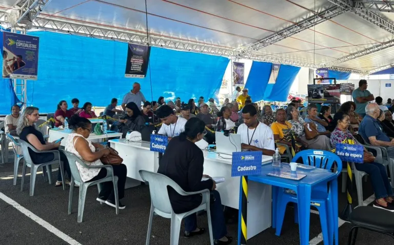 Estrutura móvel montada no Londrina Norte Shopping agiliza a fila de espera do SUS. Para que o ritmo de atendimentos continue, Secretaria de Saúde faz apelo para que pacientes atualizem seus telefones nas UBSs.Em apenas duas semanas de funcionamento no estacionamento do Londrina Norte Shopping, as unidades móveis do programa Agora tem Especialistas já transformaram a realidade de centenas de londrinenses. Mais de 600 cirurgias de catarata foram realizadas, e o local segue recebendo diariamente pacientes para os acompanhamentos de pós-operatório, que começam logo no dia seguinte à intervenção.A estrutura ágil e o atendimento em série têm sido a solução para encurtar uma fila de espera que, para muitos, significava a perda gradual da independência e da qualidade de vida.A alegria de voltar a enxergar
A recuperação da visão tem trazido alívio imediato para os pacientes. Terezinha Vicente da Costa aguardava na fila desde a sua primeira consulta, há quase um ano.“Eu nunca tinha feito cirurgia. Já não estava enxergando nada, só uma fumaça tampando tudo. Me dava uma tristeza, porque se minhas amigas não parassem para falar comigo eu nem sabia quem era. Agora, assim que operei já estou enxergando bem. Está mil maravilhas”, comemorou Terezinha.Aos 75 anos, dona Maria das Dores da Silva também compareceu à carreta para o primeiro retorno após operar o olho direito. Amparada pela filha Alessandra, ela elogiou o acolhimento da equipe, que não a deixou sentir dor, e já faz planos para o fim do resguardo: "Gosto muito de cozinhar. Assim que tiver alta, vou fazer muito salgado".O sentimento é compartilhado pela costureira Irene Lopes Pinheiro, que retornou para avaliar o olho direito e já está com a cirurgia do esquerdo agendada na unidade móvel. "Quando passar a recuperação, o dia a dia vai voltar ao normal, quero principalmente voltar a costurar", projetou.O trabalho nos bastidores
Para que a linha de cuidados funcione de forma ágil, uma equipe de mais de 40 profissionais atua nas unidades móveis. O protocolo exige que, nos 30 dias após a cirurgia, cada paciente passe por quatro consultas de retorno. Todo esse acompanhamento é garantido pela equipe da carreta, mesmo quando a estrutura for deslocada para outro município.Para os profissionais, o ritmo intenso é compensado pelos resultados. A médica oftalmologista Malu Inês Perez Moura, natural de Londrina, celebra a chance de atuar em sua cidade após seis anos viajando o Brasil com o programa. "É corrido, mas muito gratificante saber que as pessoas vão melhorar a visão. A maior parte do nosso público tem mais de 60 anos, e eles estão amando voltar a enxergar", relatou.Atenção à fila de espera: atualize seu cadastro!
Apesar do sucesso das cirurgias, a Secretaria Municipal de Saúde enfrenta um obstáculo comum: a dificuldade em localizar os pacientes na fila devido a telefones desatualizados.A assessora da pasta, Kátia Silva, reforça que o trabalho de agendamento segue intenso e pede a colaboração da população. Se você ou algum familiar aguarda por consultas ou cirurgias oftalmológicas, siga as orientações abaixo:Atualize seus dados: Vá até a Unidade Básica de Saúde (UBS) mais próxima da sua residência e confirme se o seu número de telefone (e de recados) está correto.Fique de olho no WhatsApp: A Secretaria de Saúde também utiliza o aplicativo de mensagens para fazer as convocações.Atenda as ligações: Nos próximos dias, não deixe de atender ligações, mesmo de números desconhecidos, pois pode ser a equipe de agendamento da cirurgia."O atendimento na carreta é em série, então é muito ágil e resolutivo", conclui Kátia Silva, lembrando que a resposta rápida do paciente garante que a fila ande para todos.